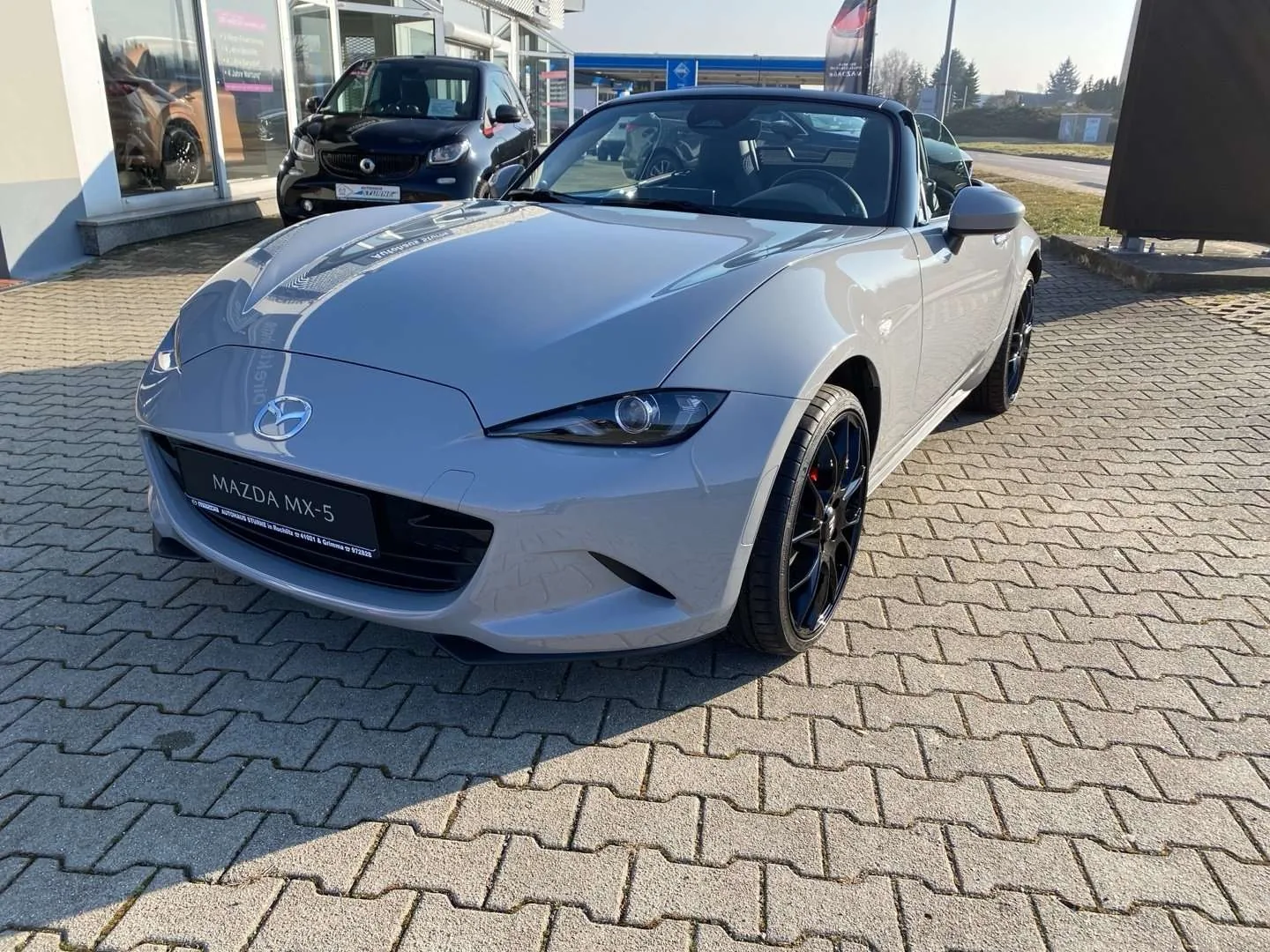 Mazda MX-5 NA rouge, phares escamotables levés, de trois quarts avant